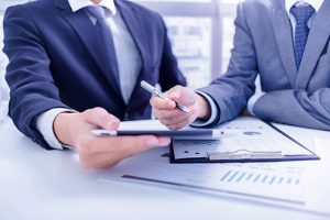 Two businessmen looking at report and having a discussion in off